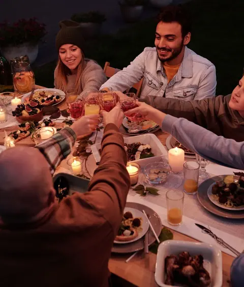 Friends and family sharing food round a table